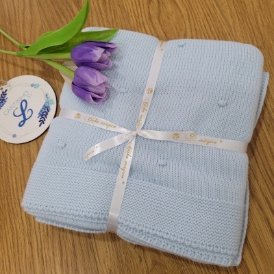 Manta azul clara de malha com flores roxas e etiqueta