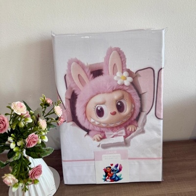 Embalagem com boneco de pelúcia rosa em forma de coelho perto de vaso com flores cor-de-rosa