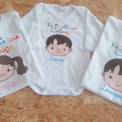 Três bodies brancos para bebés com desenhos e nomes coloridos