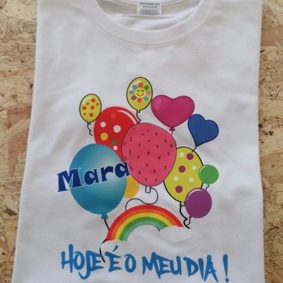 T-shirt branca com estampa colorida de balões e texto 'HOJE É O MEU DIA !'
