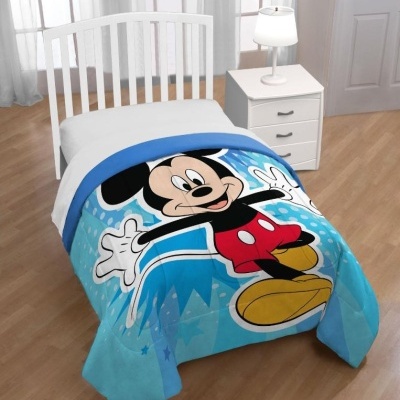 Cobertor infantil azul com Mickey Mouse numa cama branca.