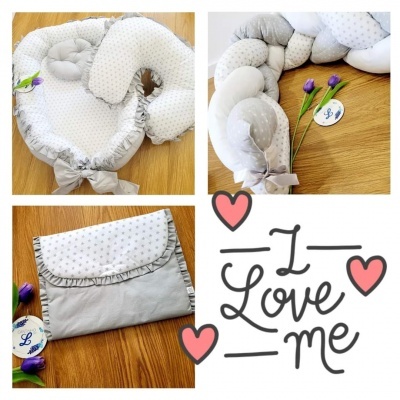 Conjunto de almofadas cinzentas com padrão de estrelas sobre chão de madeira e flores roxas