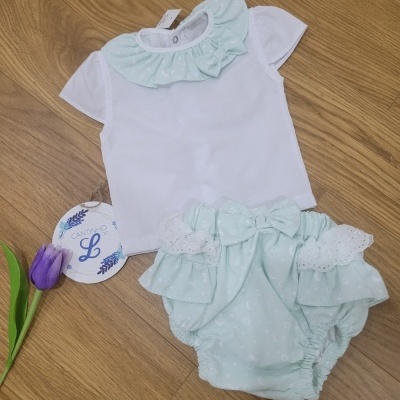 Conjunto de roupa para bebé com t-shirt branca e cuecas azul claras com laço e gola franzida