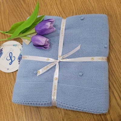 Manta azul clara de malha com fita e tulipas roxas