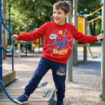 Rapazinho a usar conjunto de roupa com estampados do Spiderman vermelho e azul no parque infantil.