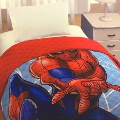 Colcha infantil azul e vermelha com padrão do Homem-Aranha sobre cama branca