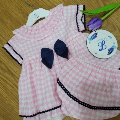 Conjunto rosa infantil com padrão de losangos, laço azul, renda preta e etiqueta CANTINHO L