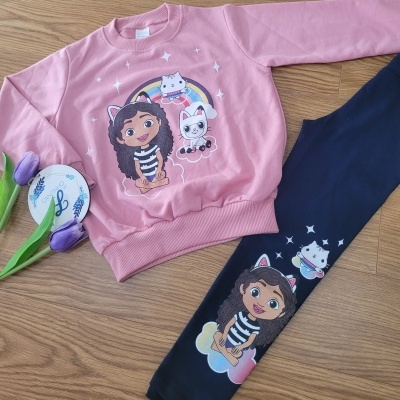 Conjunto infantil com camisola rosa e leggins azuis escuras com desenho de menina e gatos.