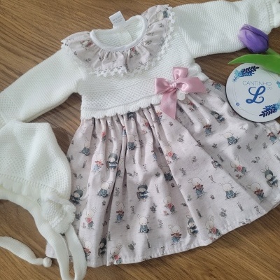 Vestido de bebé branco com saia com padrão de coelhos e flores e touca branca, tulipa roxa e caixa redonda branca