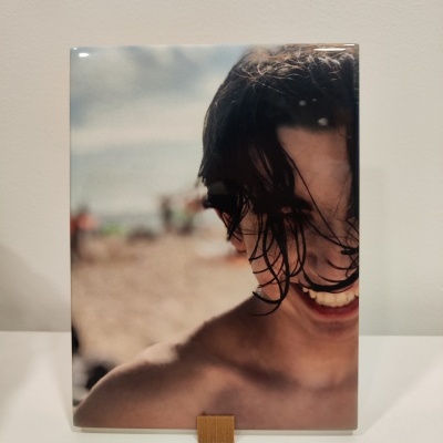 Azulejo com imagem de rosto sorridente de jovem na praia