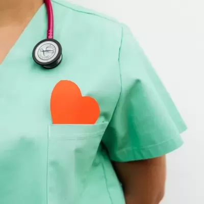 Uniforme verde claro com estetoscópio vermelho e coração de papel no bolso