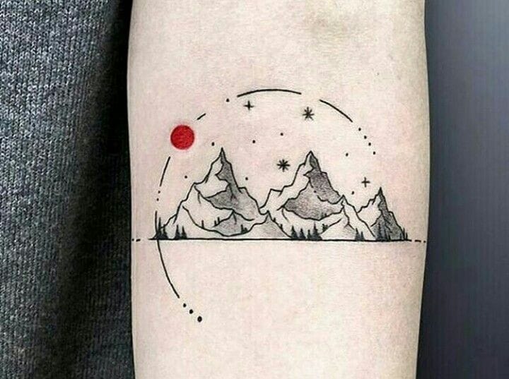 Tatuagem minimalista de montanhas com sol vermelho e estrelas no braço