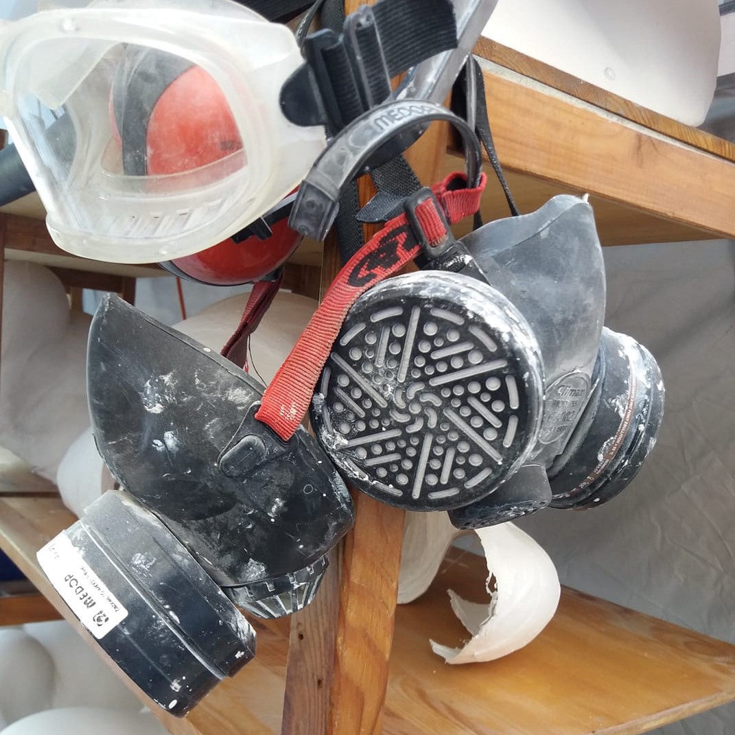 Máscara de proteção respiratória preta com filtros circulares e correias vermelhas