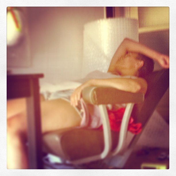 Pessoa reclinada numa cadeira de couro castanho com estrutura metálica num ambiente interior