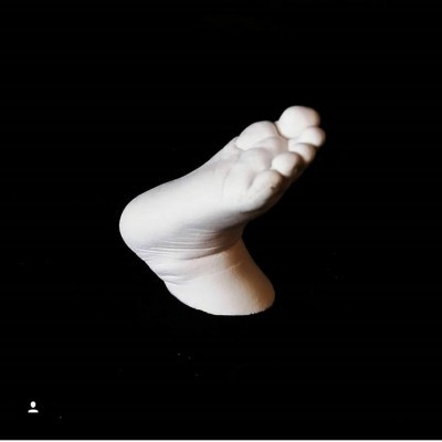 Estátua branca de pé humano com fundo preto