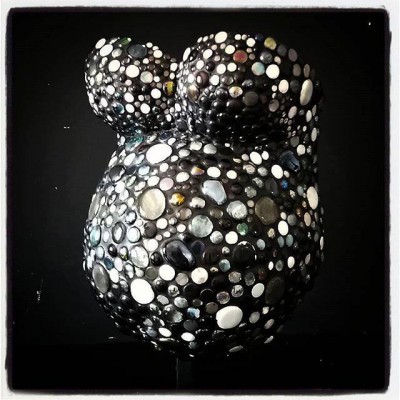 Máscara ou escultura decorativa preta com texturas circulares coloridas