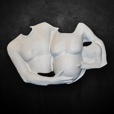 Escultura de dois torsos humanos brancos entrelaçados em fundo escuro