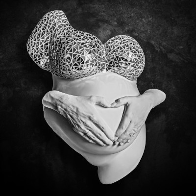 Escultura artística torso feminino grávido com padrão triangular no peito e mãos na barriga