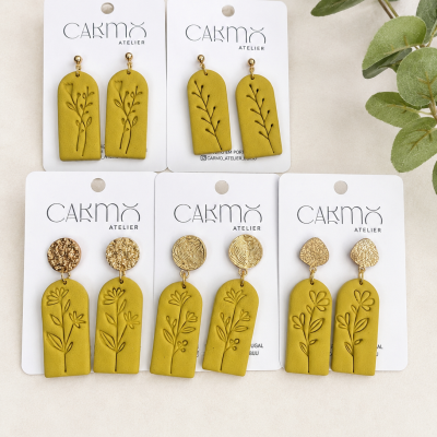 Cinco pares de brincos amarelos com padrões florais em cartões da marca CAKMO ATELIER