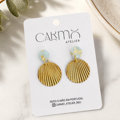 Brincos dourados e azul claro em cartão branco Carmo Atelier