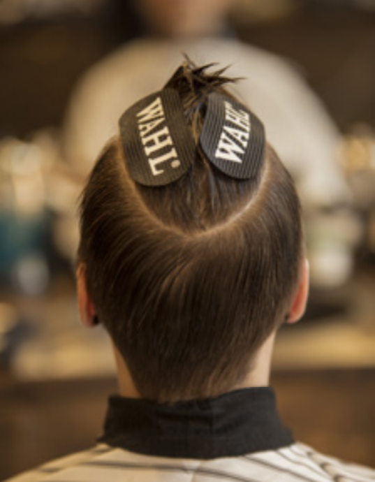 Cabeça vista de trás com cabelo curto penteado e presilhas WAHL em barbearia