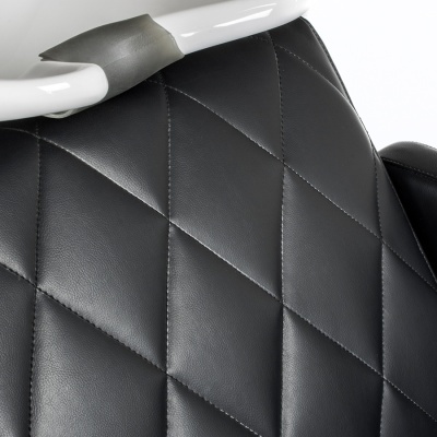 Encosto de cadeira de couro sintético preto com costura em losangos e estrutura metálica branca