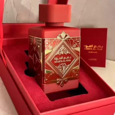 Frasco de perfume vermelho com detalhes dourados em caixa vermelha