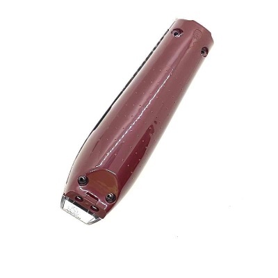 Aparelho de cortar cabelo vermelho com lâmina metálica e parafusos pretos