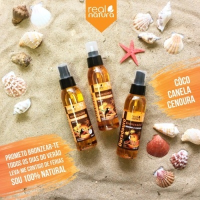 Três frascos de spray bronzeador Real Natura em areia com conchas e texto promocional.