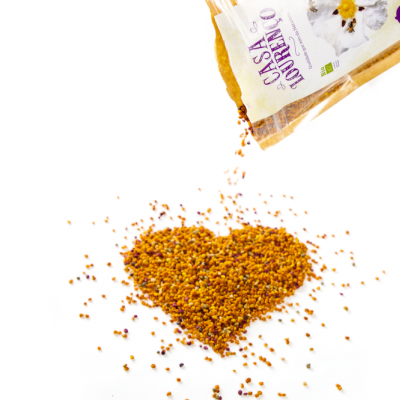 Pacote de pólen de abelha a derramar grânulos em forma de coração