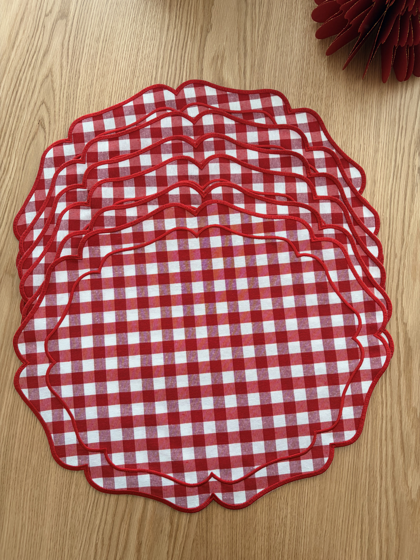 Conjunto de individuais de mesa em tecido xadrez vermelho e branco sobre superfície de madeira
