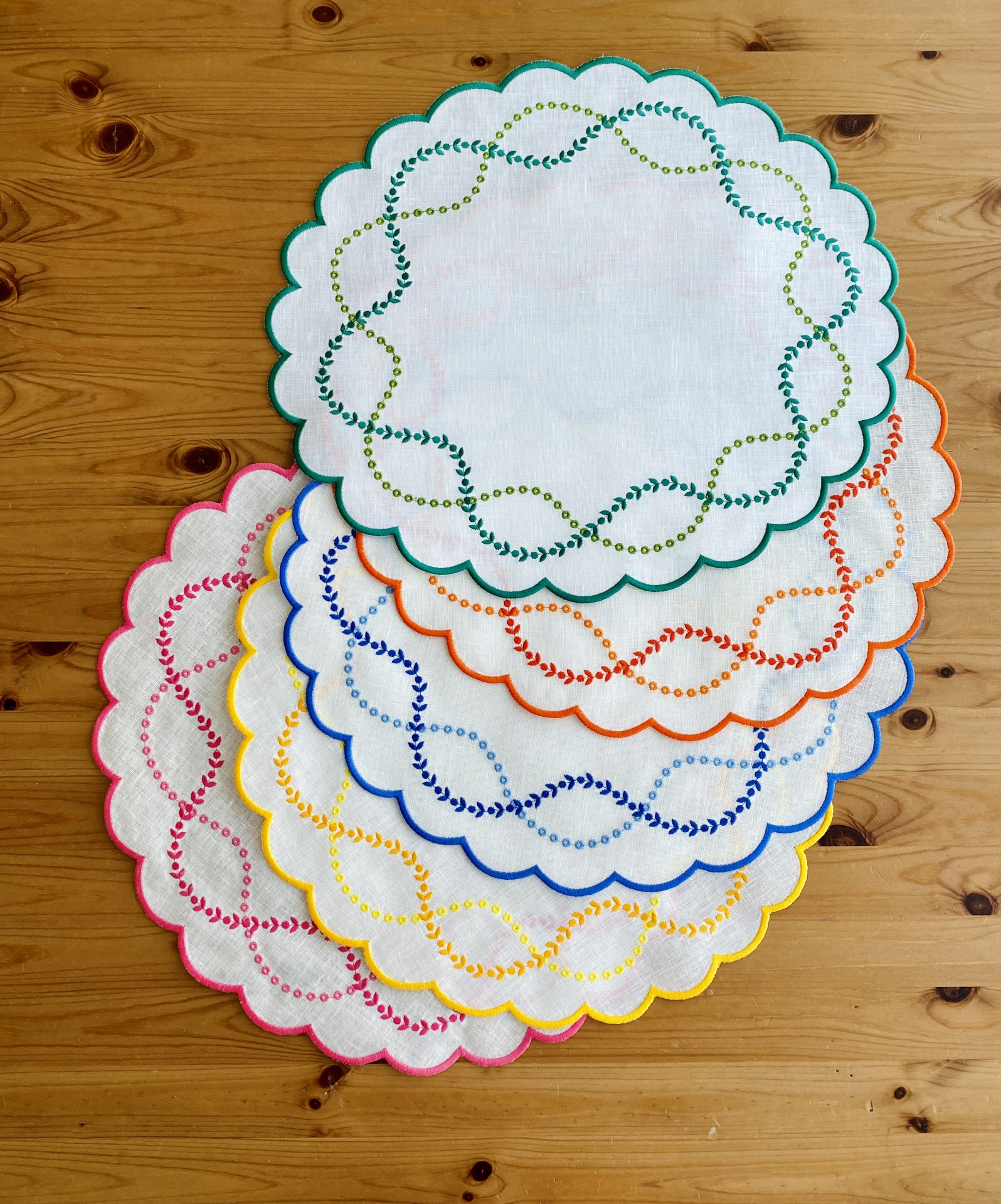 Conjunto de toalhetes redondos com bordados coloridos e bordas onduladas