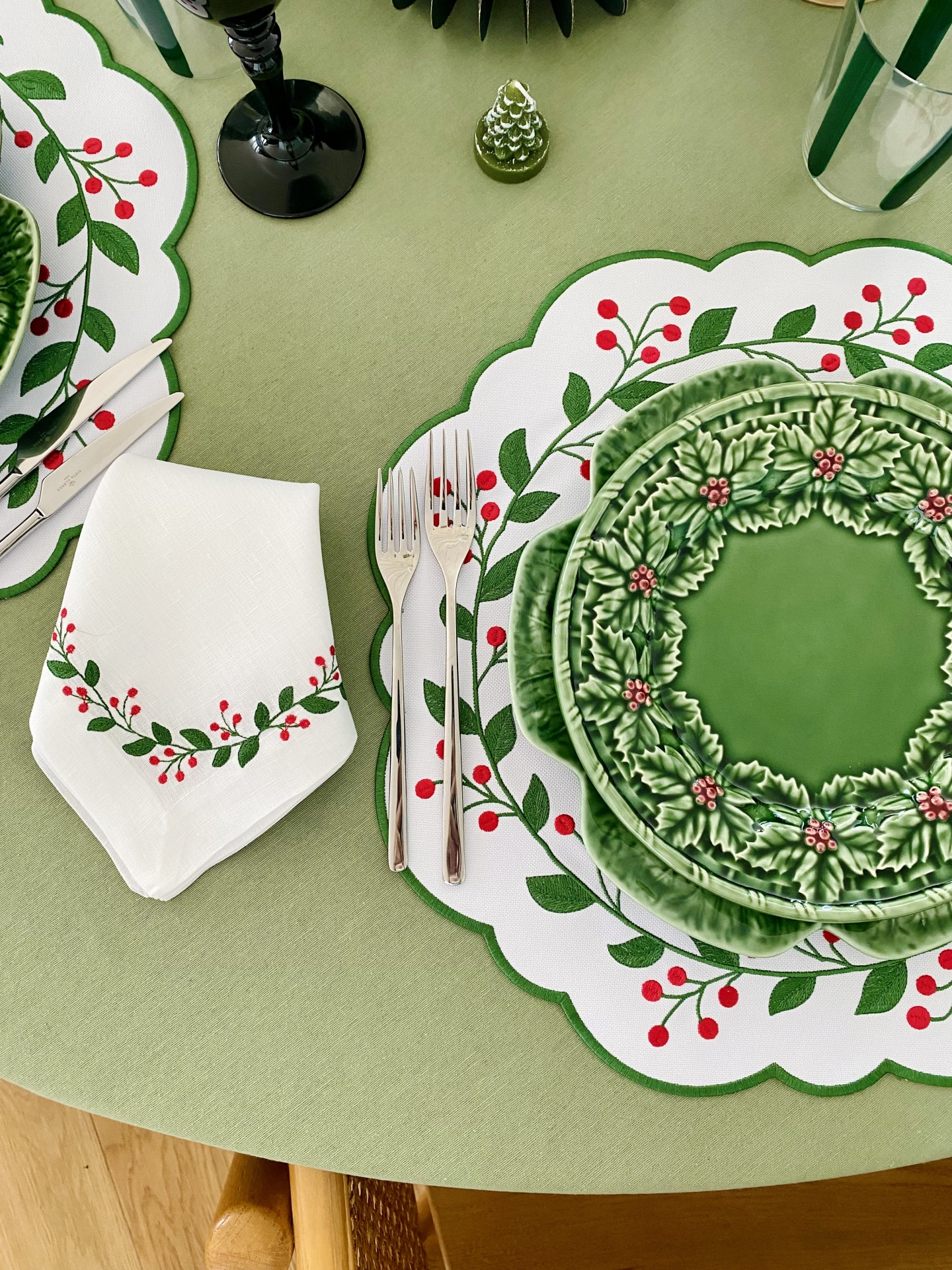 Conjunto de mesa de Natal com pratos, guardanapo e toalha decorados com folhas de azevinho e bagas vermelhas