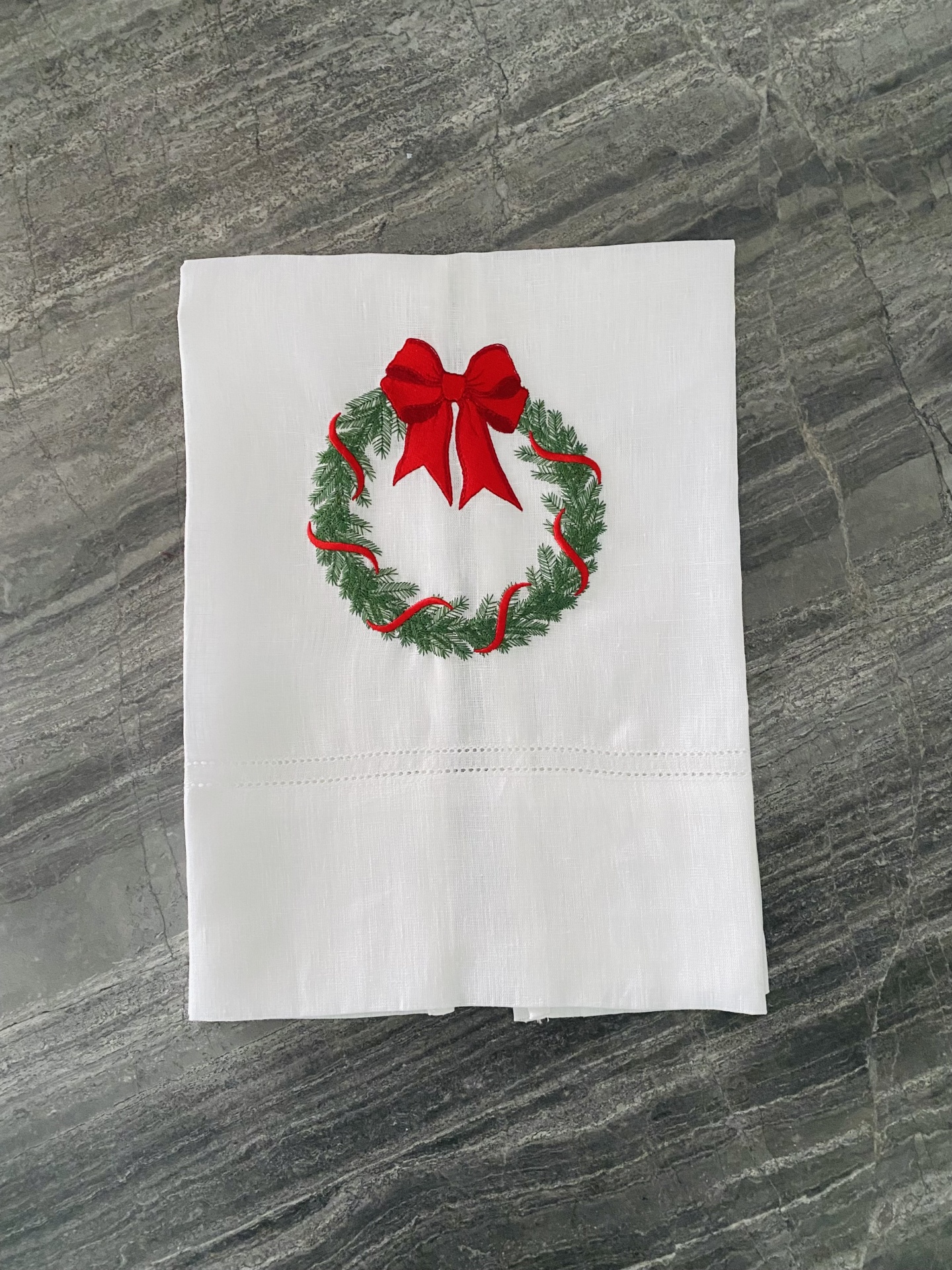 Guardanapo branco com bordado de coroa de Natal com laço vermelho