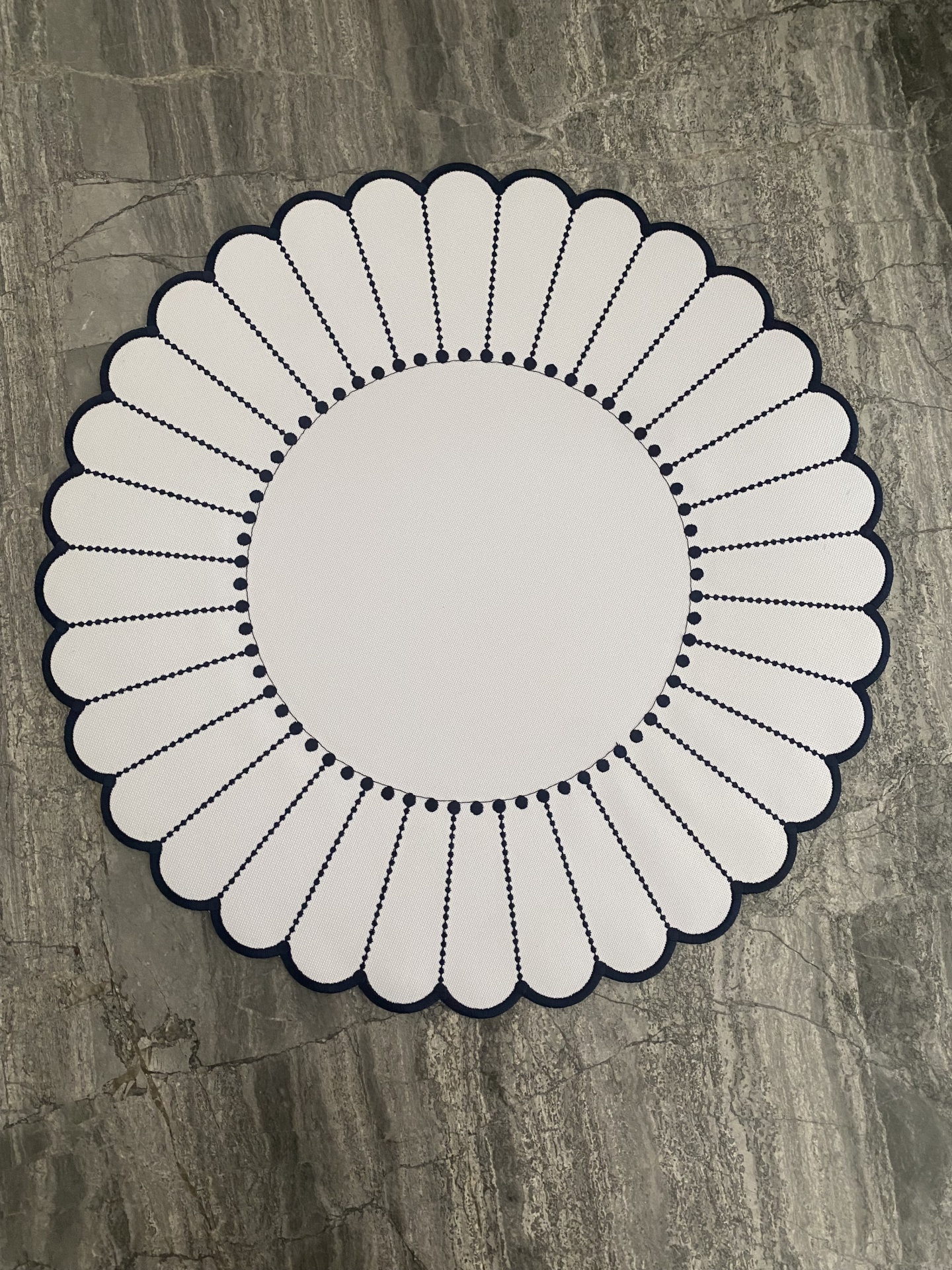 toalha de mesa redonda branca com padrão festonado e bordas azuis