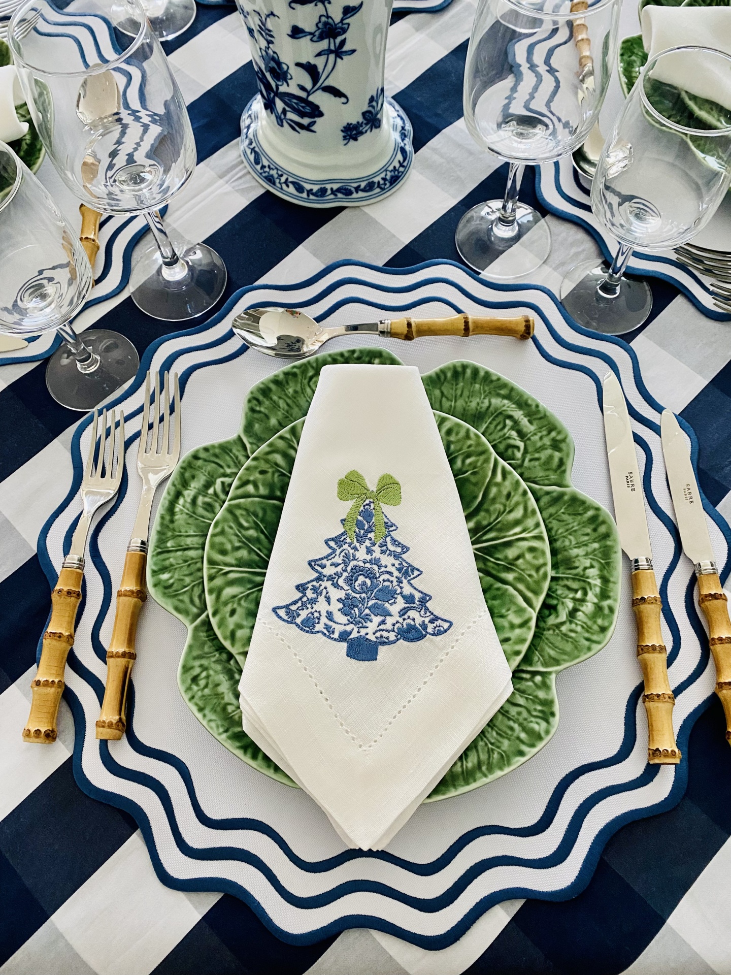Conjunto de talheres, pratos e guardanapo decorativo sobre mesa listrada azul e branca