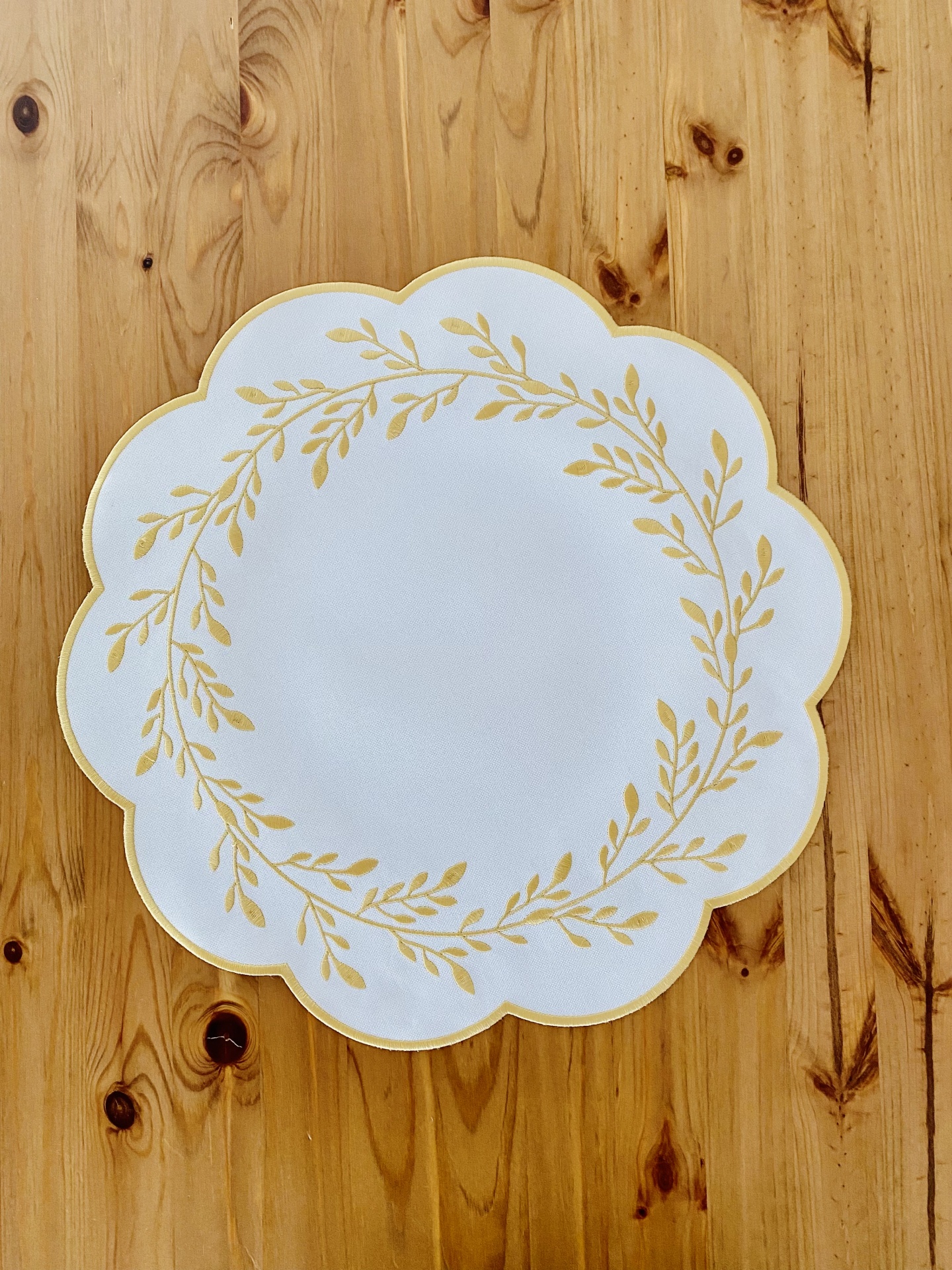 Prato branco com padrão dourado em mesa de madeira