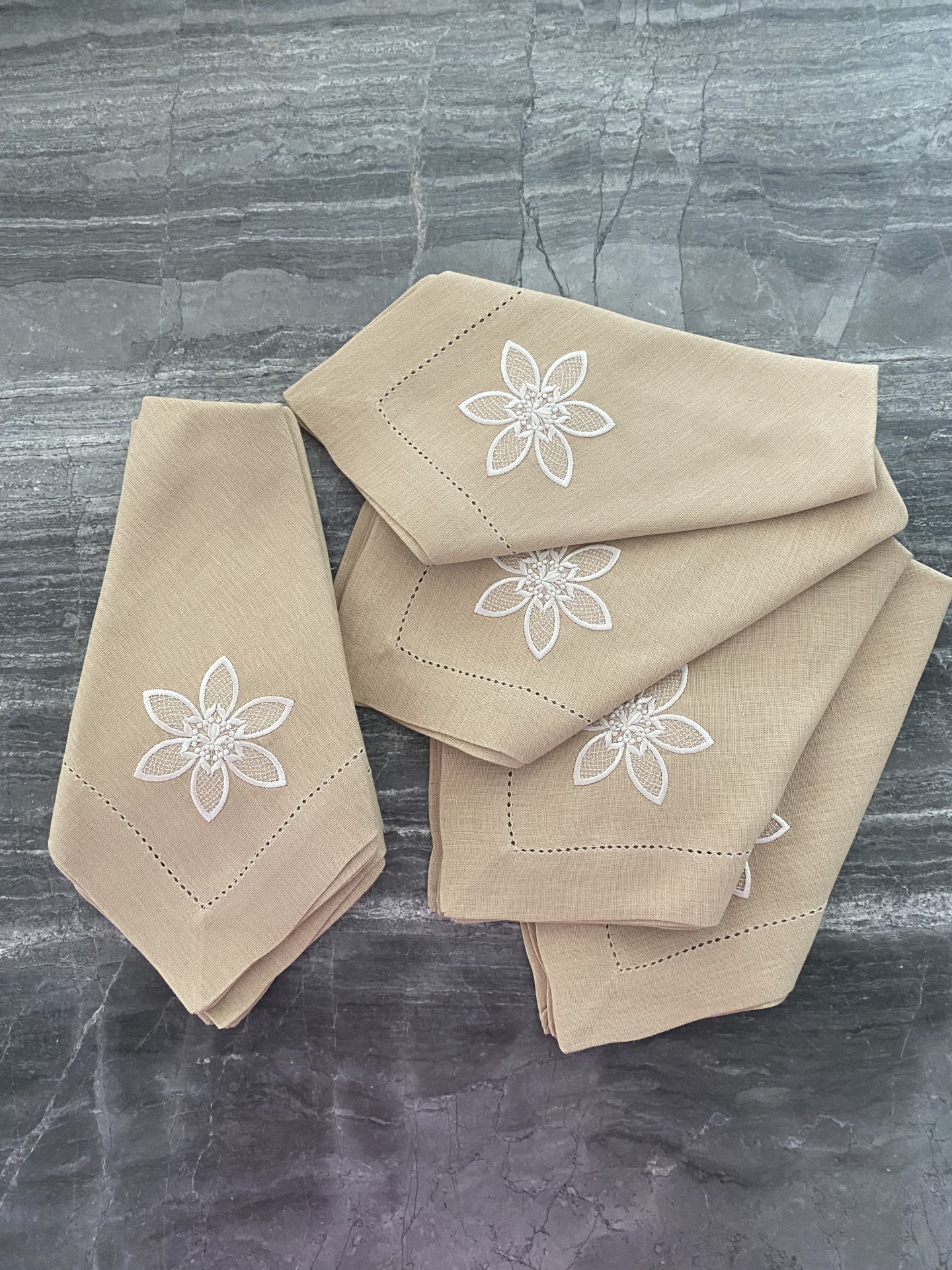 Guarda-napos de tecido bege com bordado floral branco