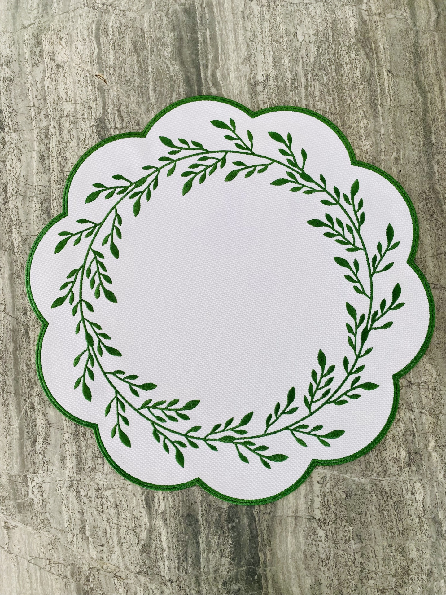 Base de mesa redonda branca com padrão de folhas verdes e borda ondulada