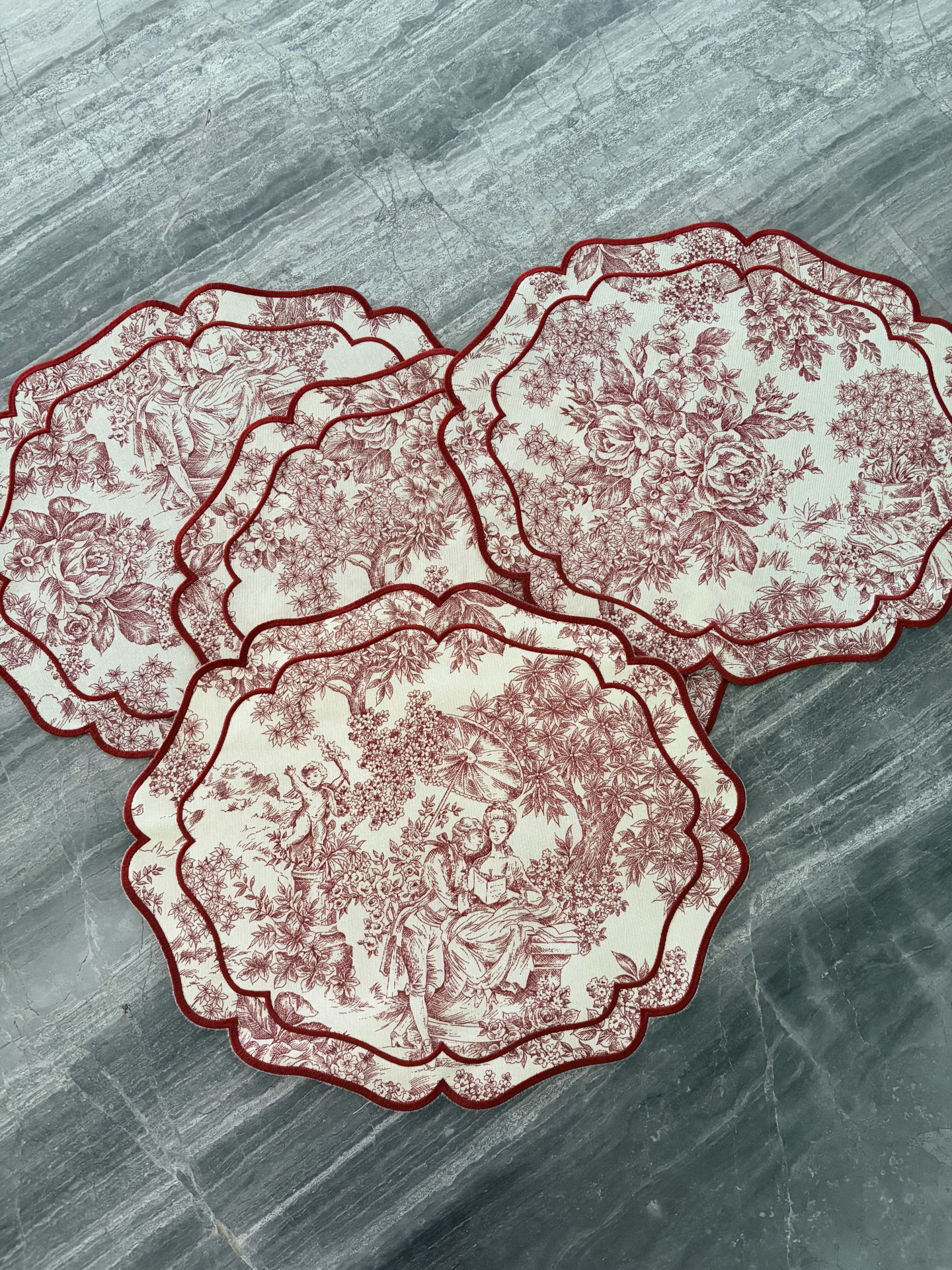 Individuais de tecido com padrão vintage vermelho e branco sobre bancada cinzenta