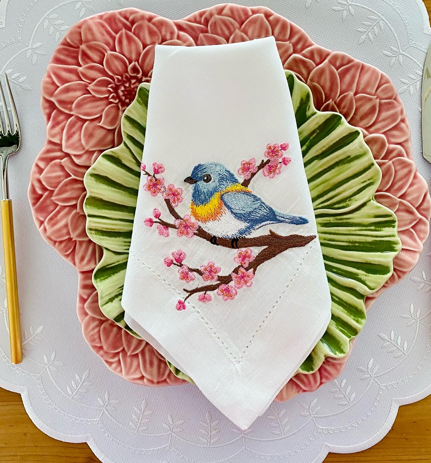Conjunto de pratos coloridos com guardanapo bordado com pássaro azul e amarelo