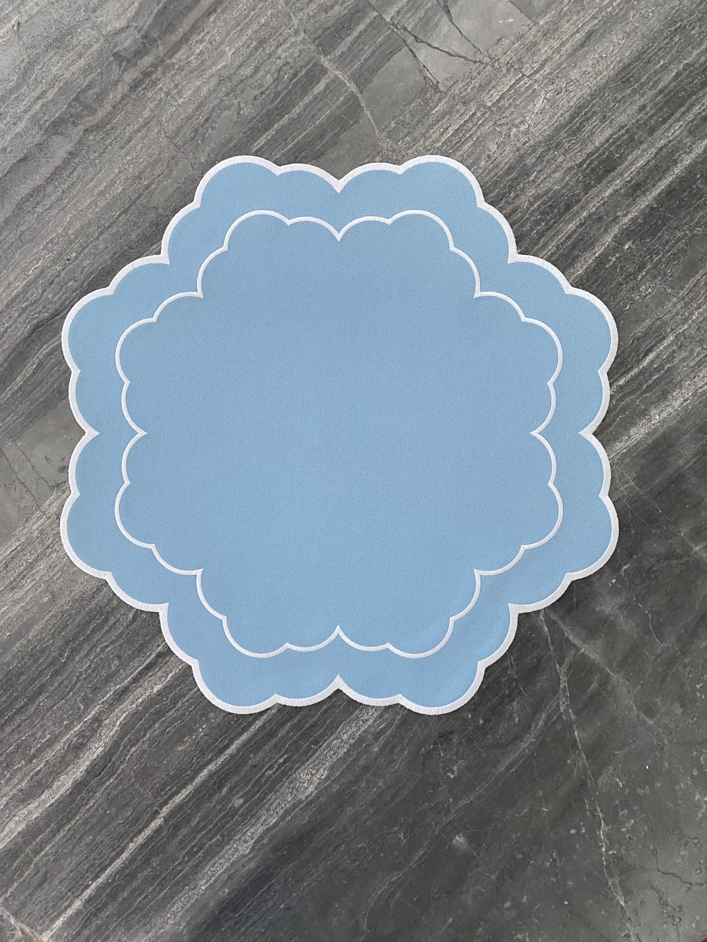 Bases para mesa azuis claros com bordas brancas sobre superfície cinzenta