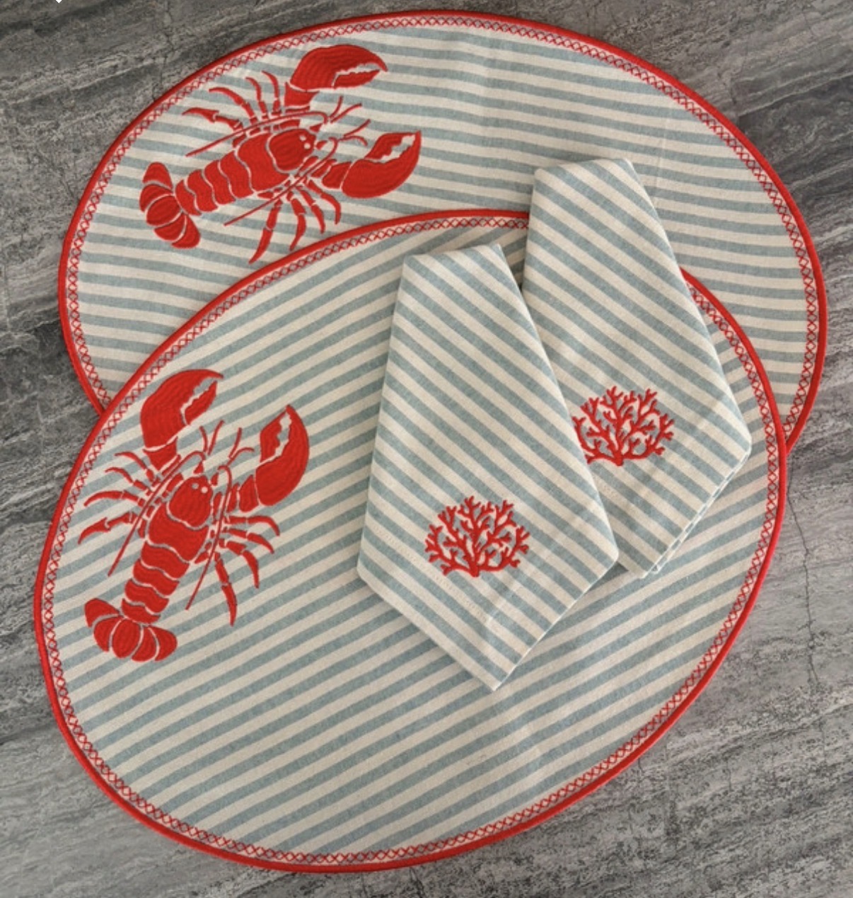 Placemats ovais riscas azuis e brancas com bordado de lagostas vermelhas e guardanapos com bordado de coral vermelho