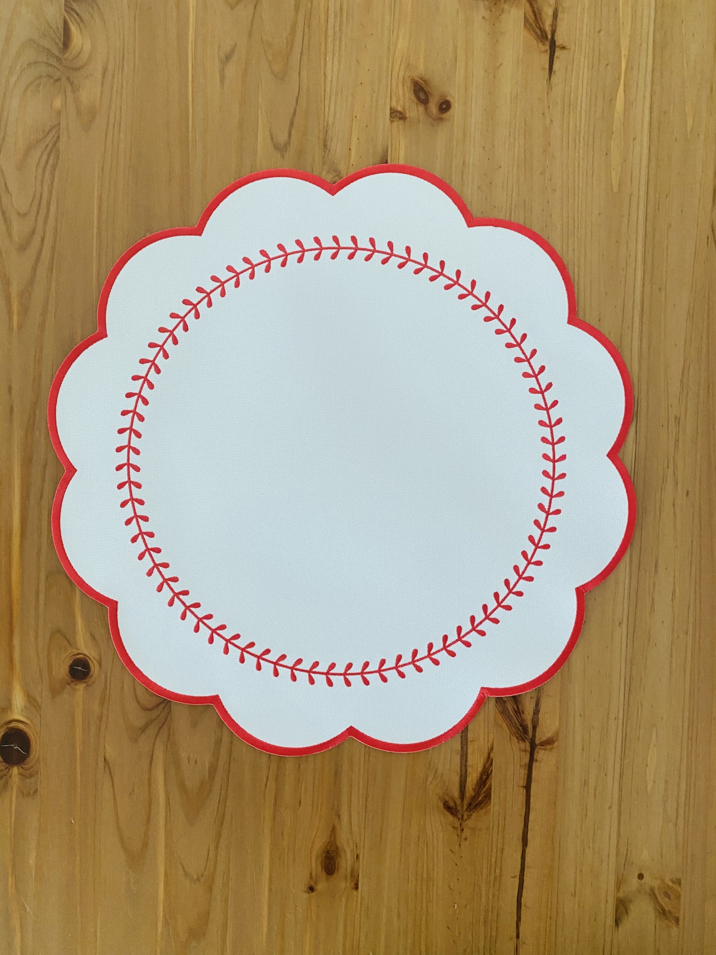 Guardanapo branco com padrão vermelho em superfície de madeira