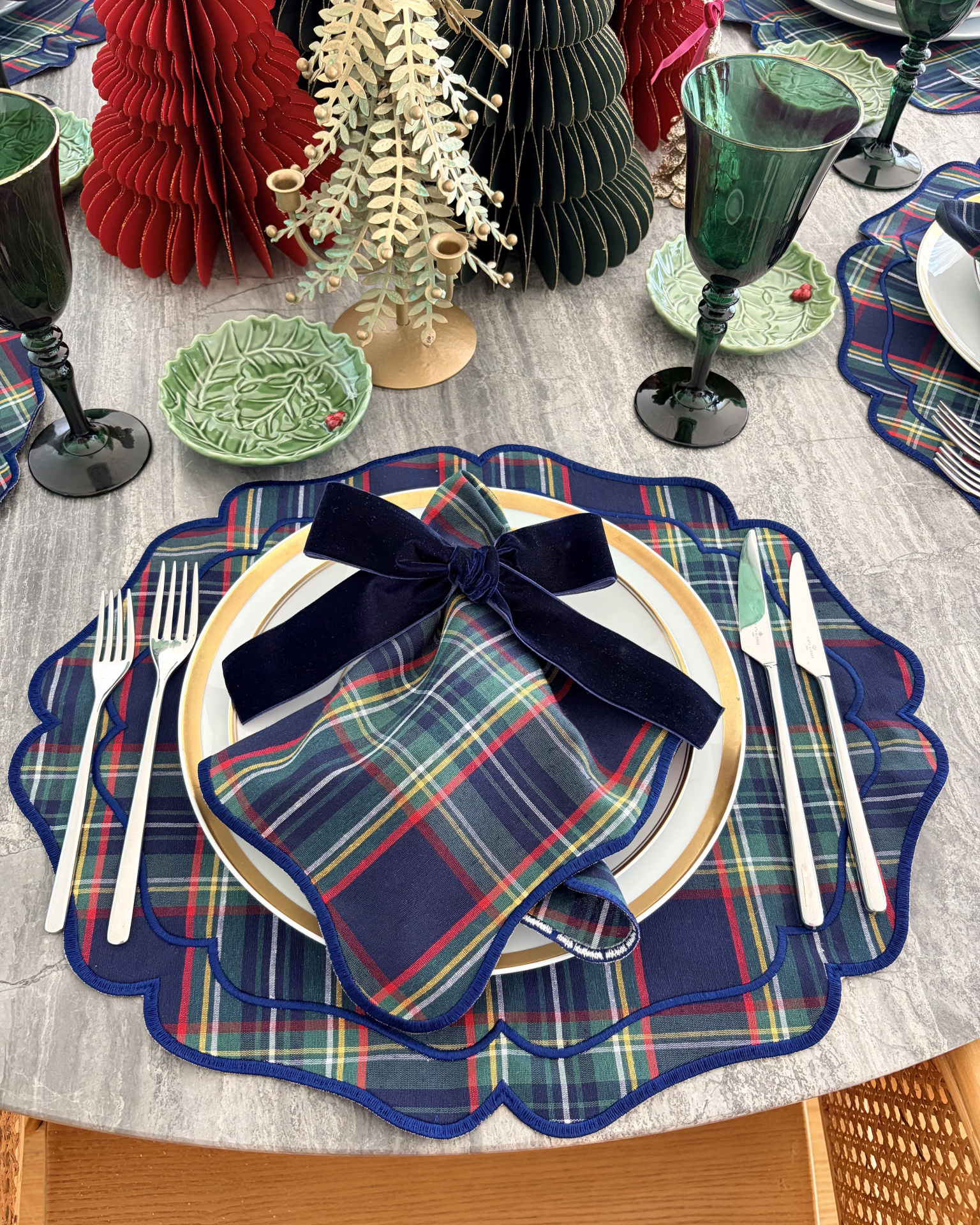Mesa posta com acessórios de tecido xadrez azul e decoração natalícia
