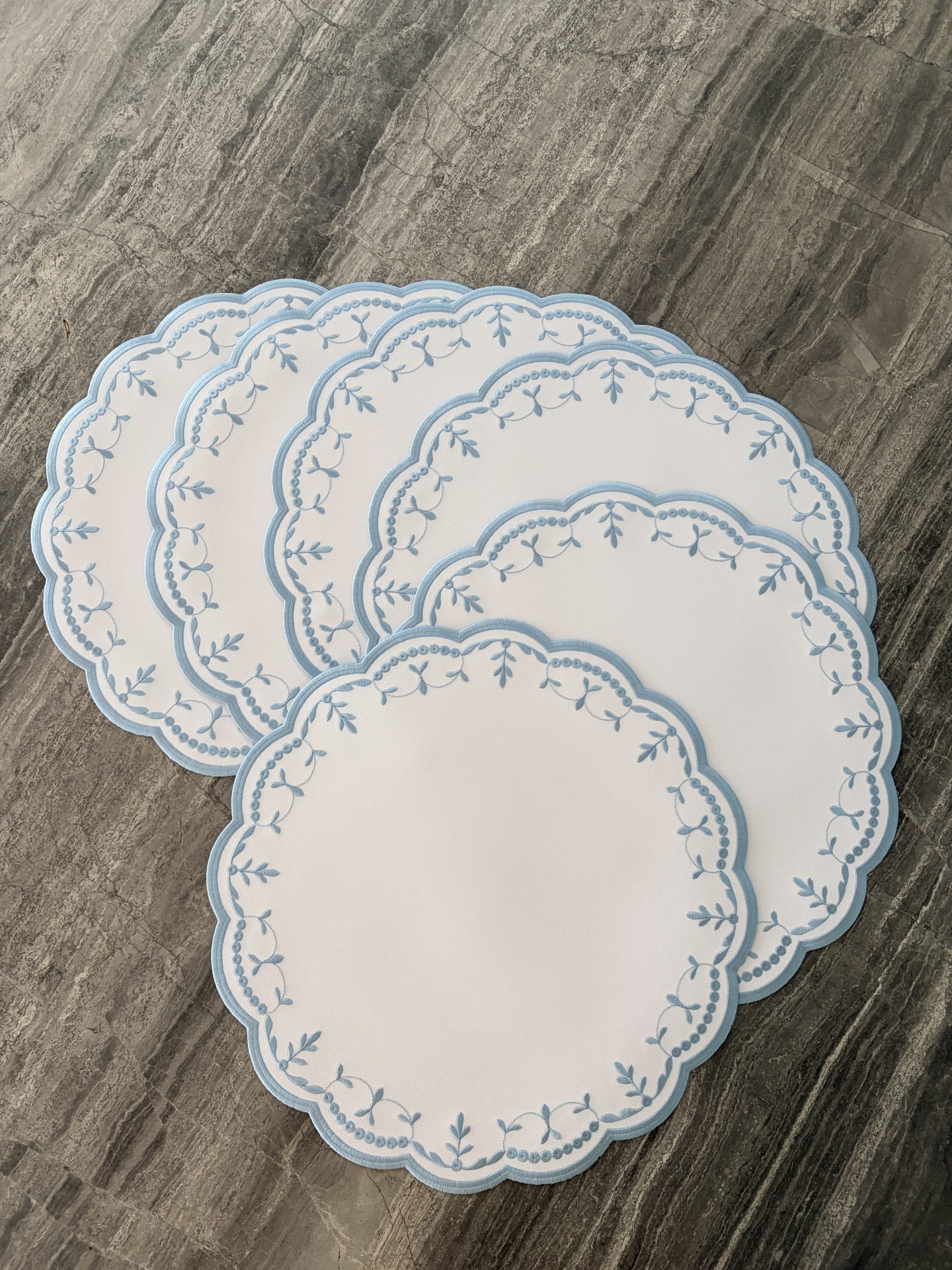 Conjunto de individuais de mesa redondos brancos com bordas e bordado azul claro