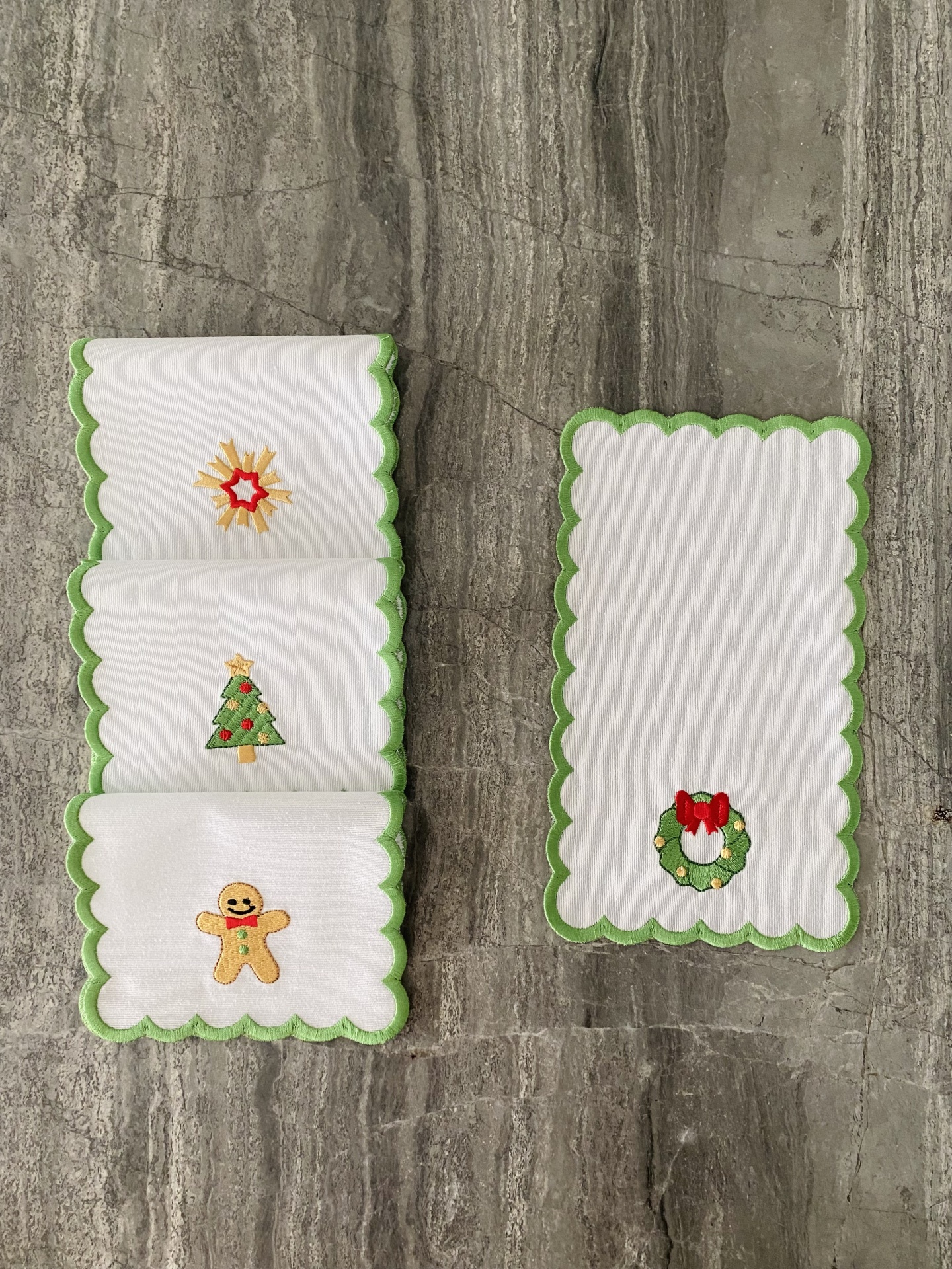 Guardanapos brancos com bordas verdes e bordados de Natal