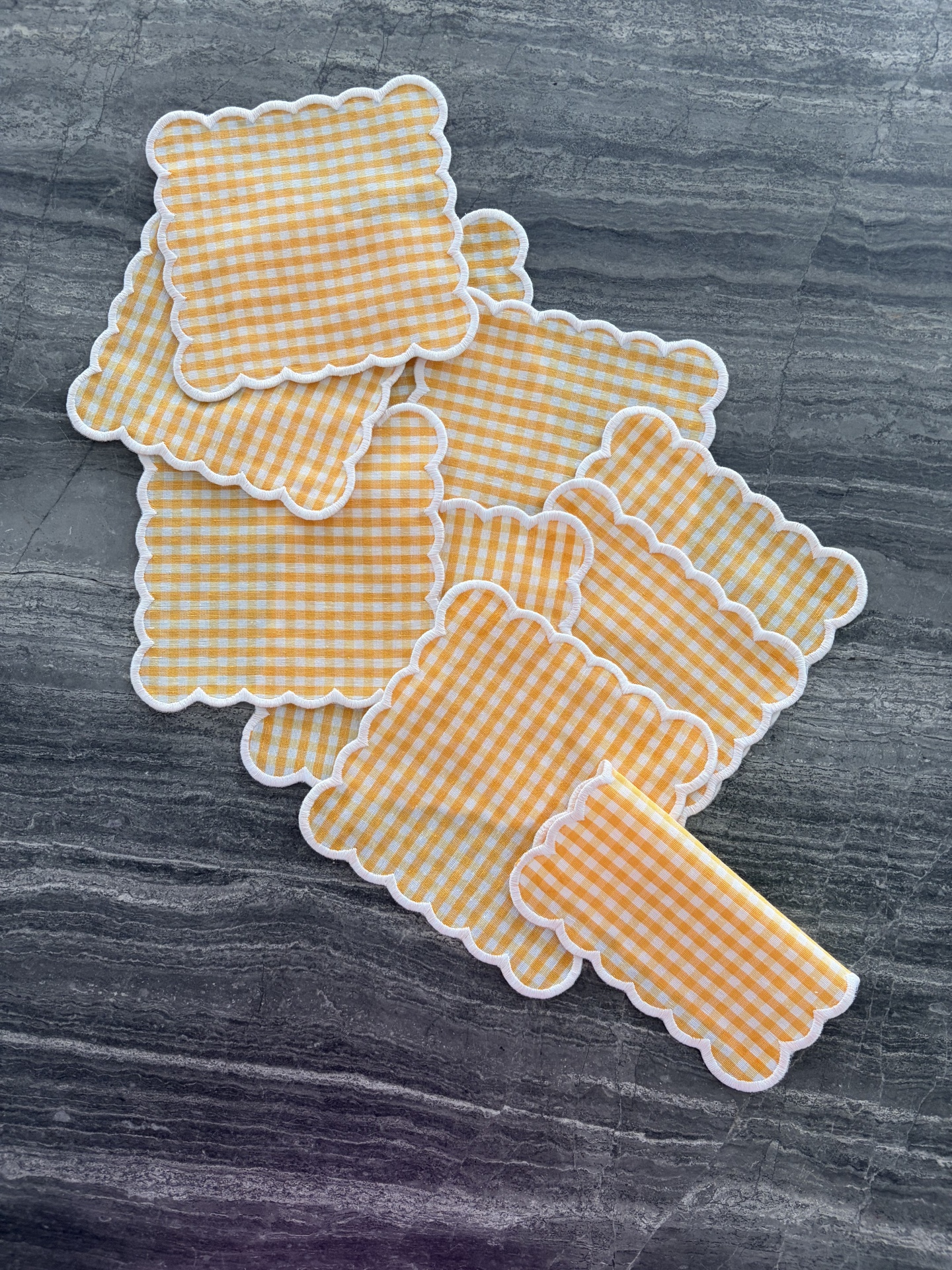 Guardanapos de tecido xadrez amarelo e branco com bordas onduladas brancas