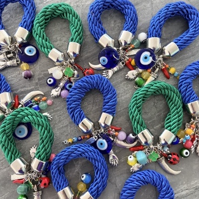 Pulseiras trançadas azuis e verdes com pendentes coloridos e olhos turcos.
