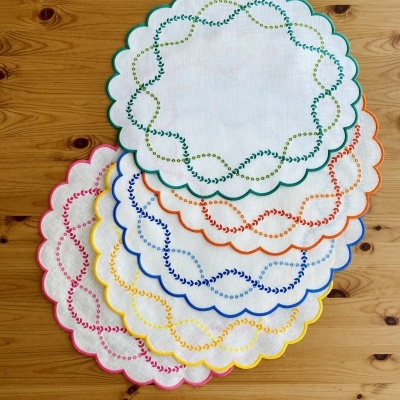 Conjunto de toalhetes redondos com bordados coloridos e bordas onduladas